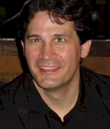 A man with dark hair and wearing black shirt.